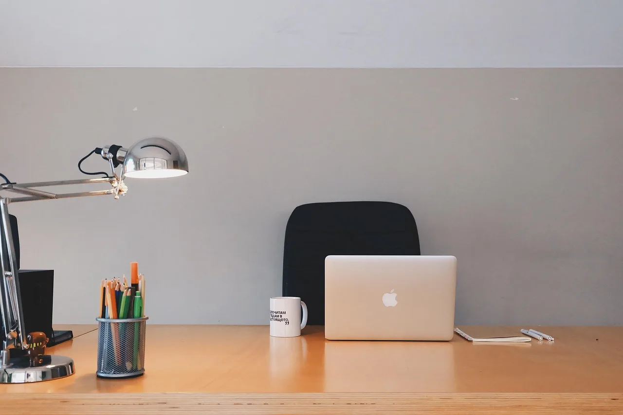 office, desk, wood, stationary, pencils, pens, lamp, coffee, cup, mug, notepad, macbook, laptop, computer, technology, business, coffee cup, gray business, gray computer, gray office, gray technology, gray coffee, gray laptop, gray wood, gray desk, gray company, gray cup, gray lamp. Coworking space equipment checklist, from essential to optional
