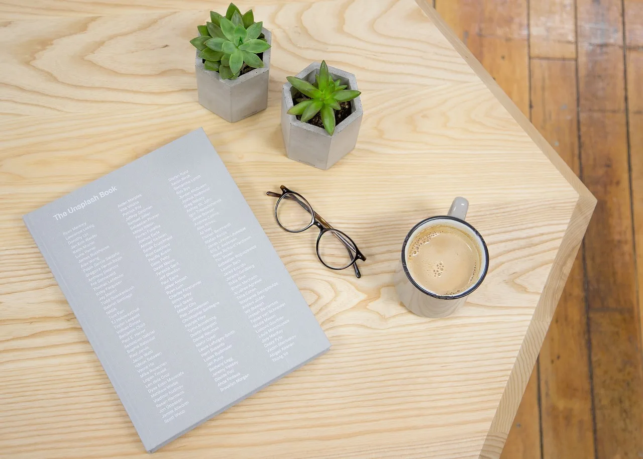 lifestyle, desk, table, wood, glasses, mug, coffee cup, coffee, book, plants, nature, brown book, brown coffee, brown books, brown table, brown desk, brown glasses. How work flows through a coworking space