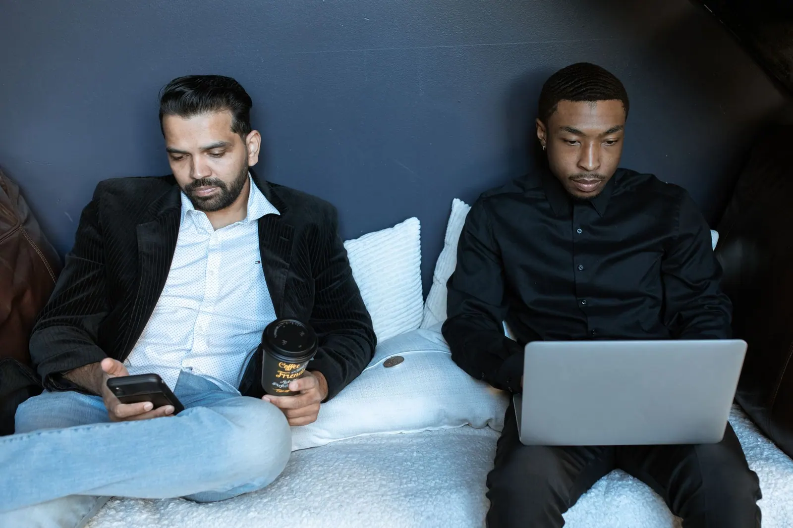 Two business professionals working on a laptop and phone in a cozy office space. Measuring service quality in a coworking space