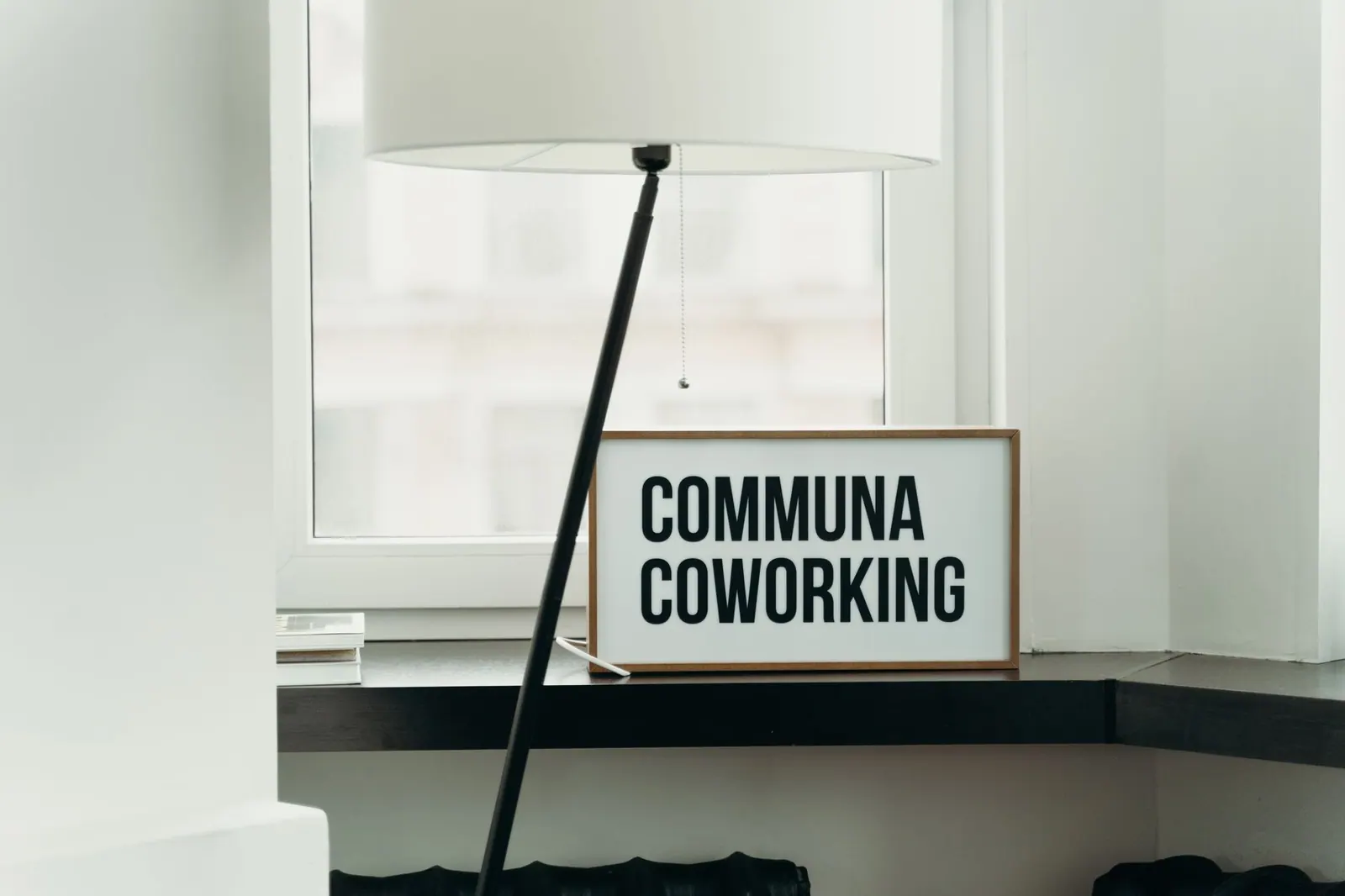 Simple and elegant coworking space decor with soft lamp lighting and window view. How to choose the right coworking space location