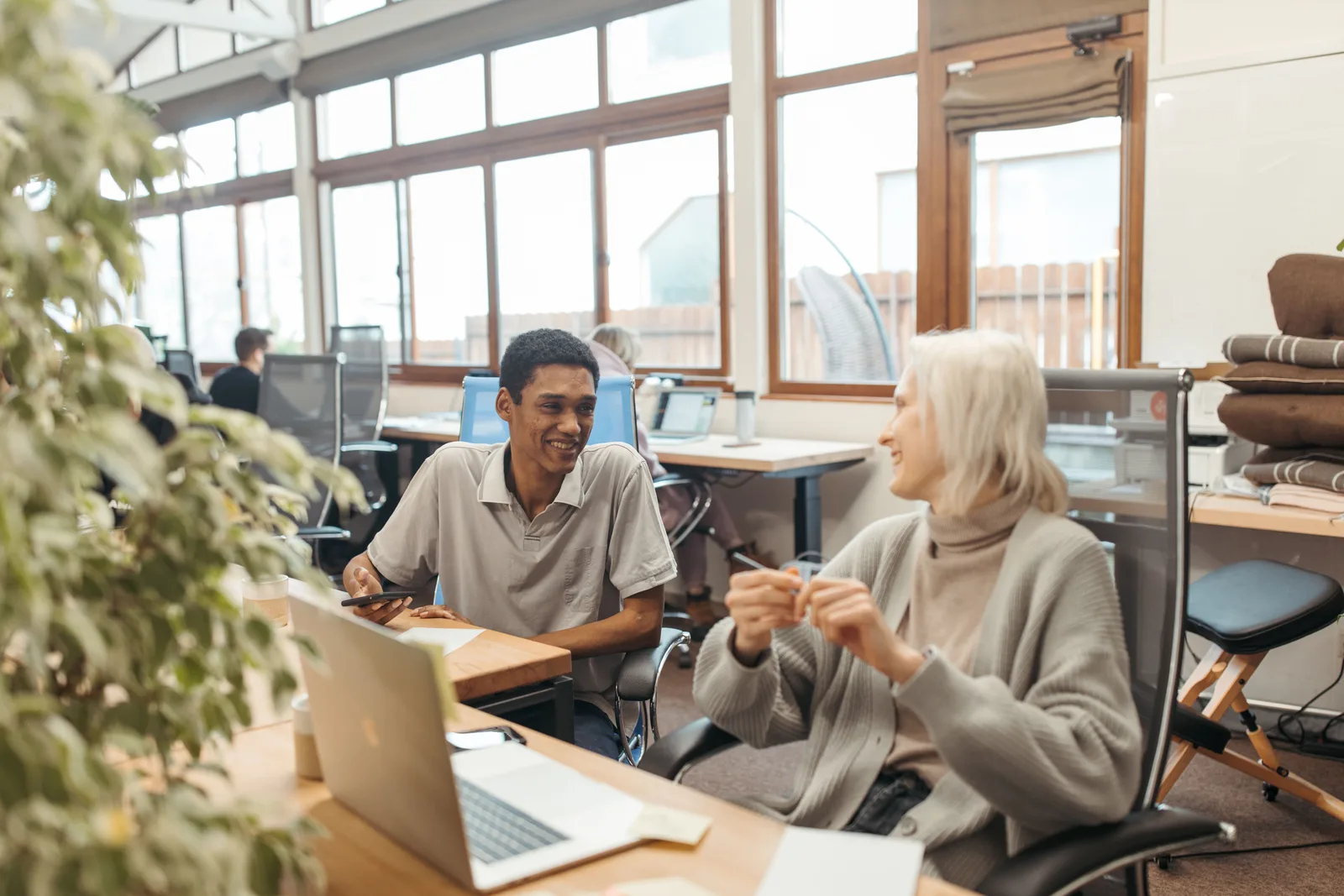 Diverse team collaborating in a creative office setting, showcasing teamwork and smiling expressions. Getting reliable hands in a coworking space