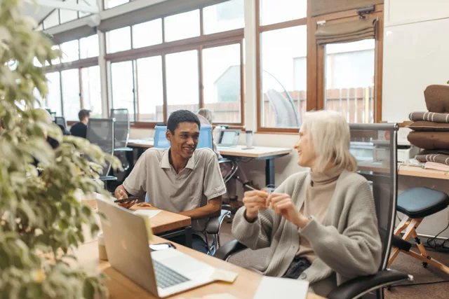 Diverse team collaborating in a creative office setting, showcasing teamwork and smiling expressions. Getting reliable hands in a coworking space