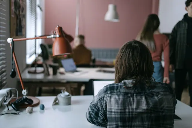 A contemporary coworking space with individuals working at their desks, showcasing a collaborative environment. How to start a coworking space in 2027 worldwide