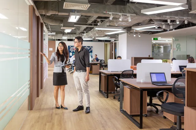 Asian professionals discussing in a contemporary office setting with open workspaces. Coworking space acquisition channels compared for real member growth